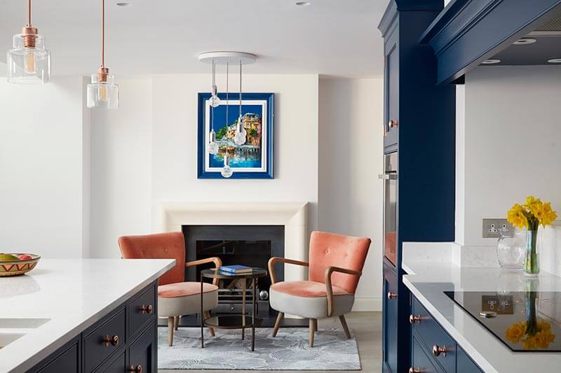 Blue open plan kitchen with armchair