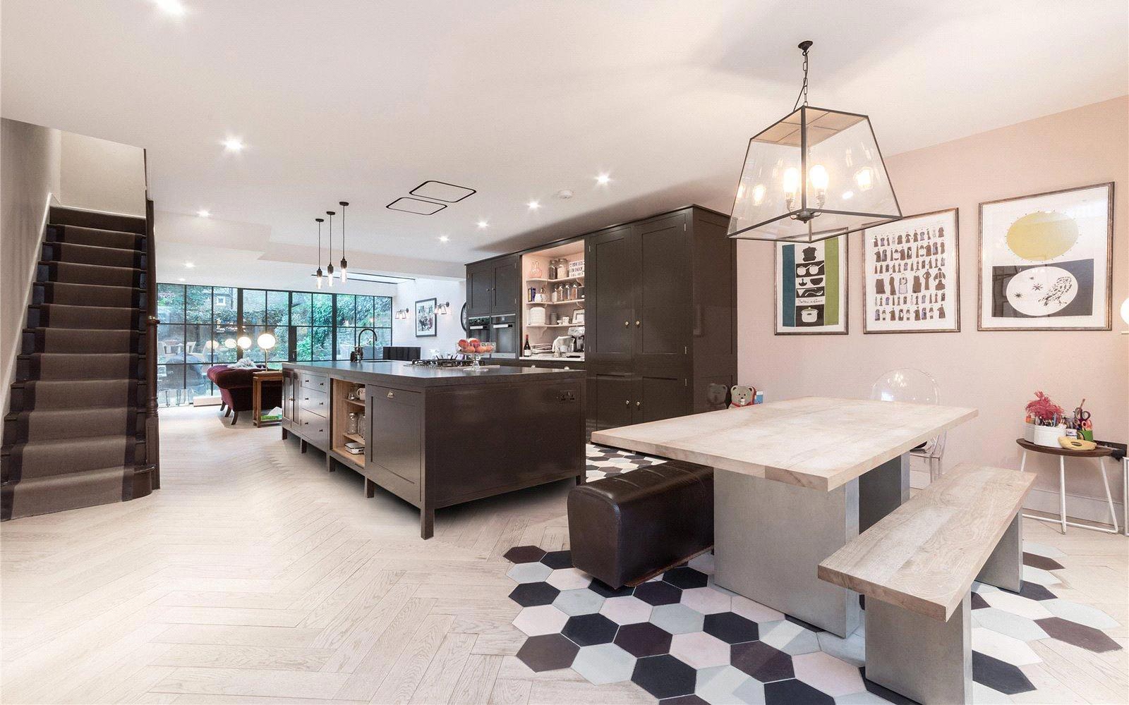 open plan brown and white kitchen with modern dining area with benches in Aberdeen Road London