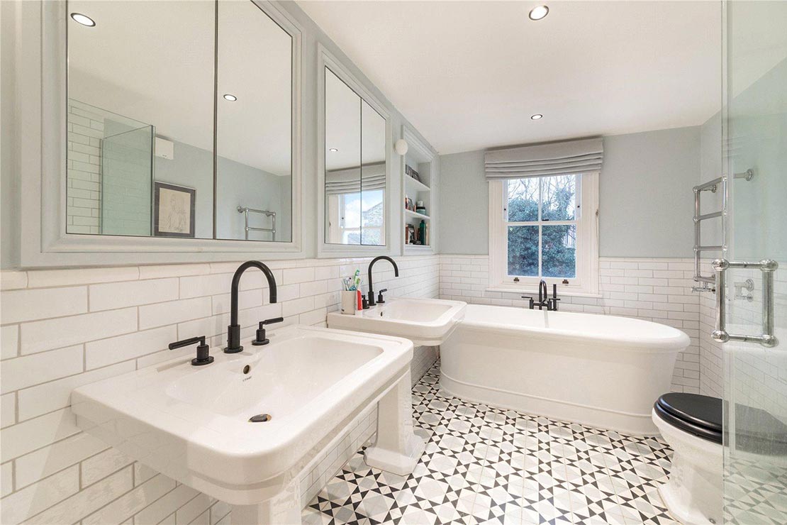modern white bathroom with dual sinks, bath tub, mirror cabinets, toilet and glass cubicle shower