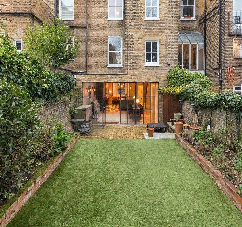 kitchen with patio and spacious back garden rear exterior