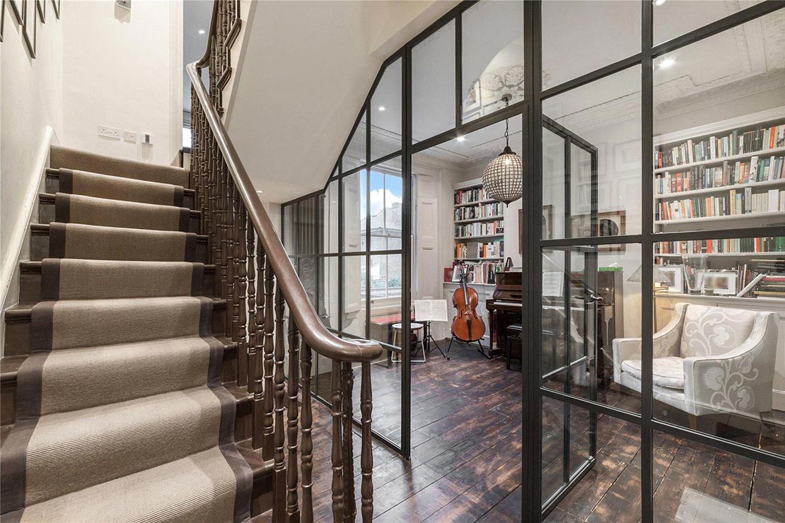 staircase with carpet in middle and glass door leading to a living room