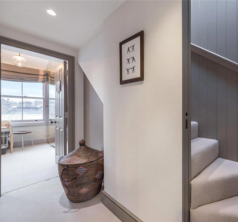 spiral white carpeted staircase and room with city views