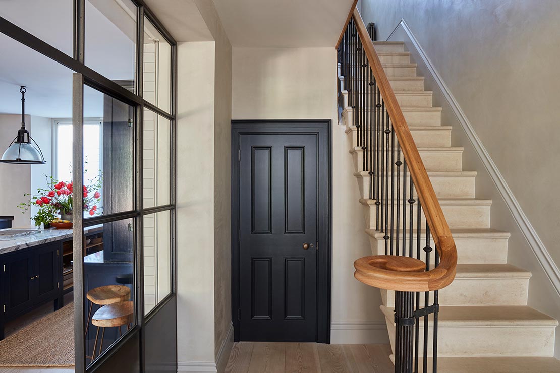 entrance with staircase with black and wooden railing