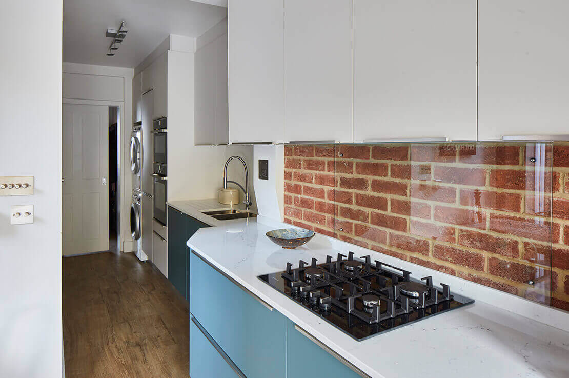 white kitchen with exposed brick wall