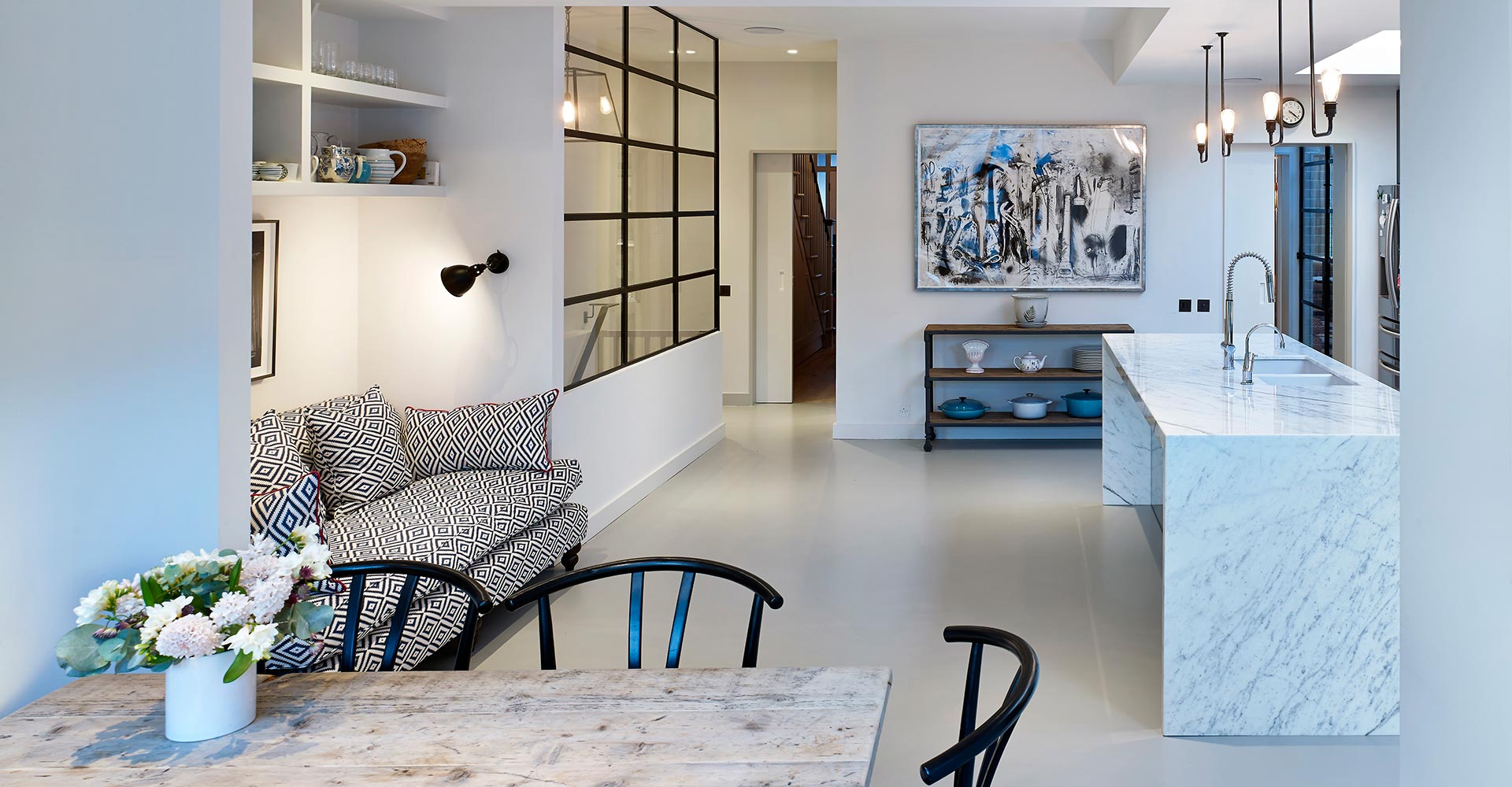 open plan kitchen with marbled island, small dining area and alcove