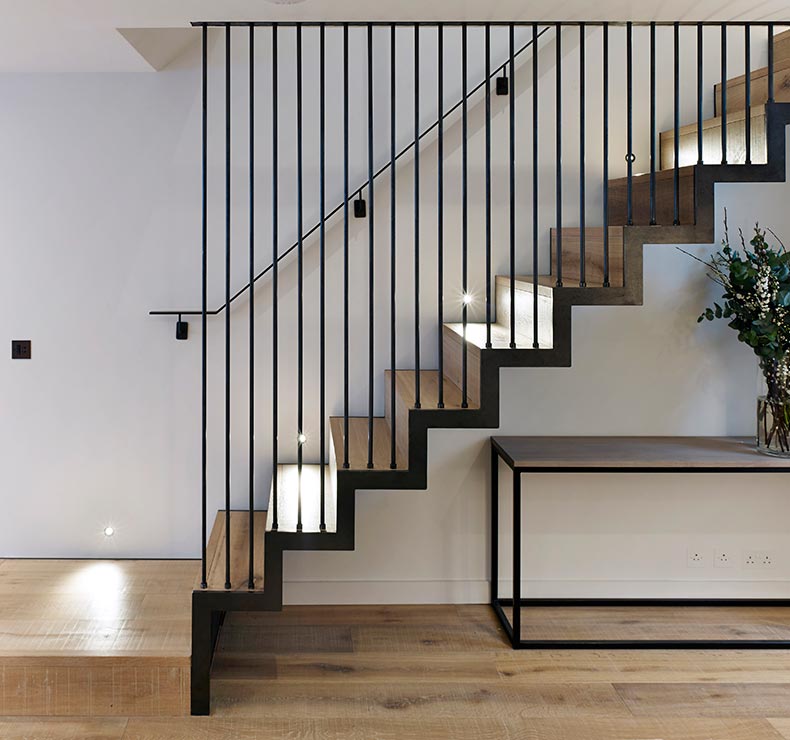 modern staircase with wooden stairs and black metal railing