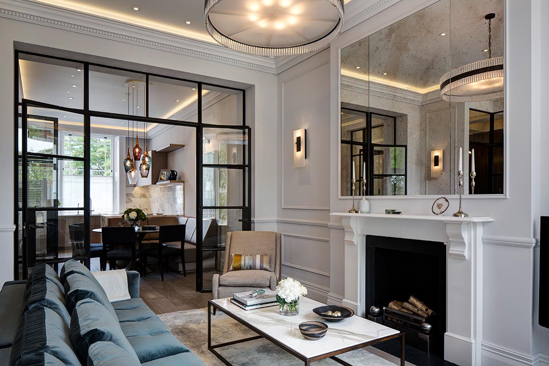 lounge area with wooden floors, fireplace and mantel with wall mirror