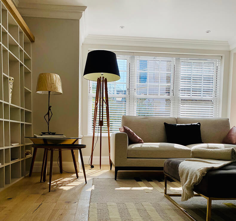 lounge room with wooden floors and louvre blinds and  built-in display case