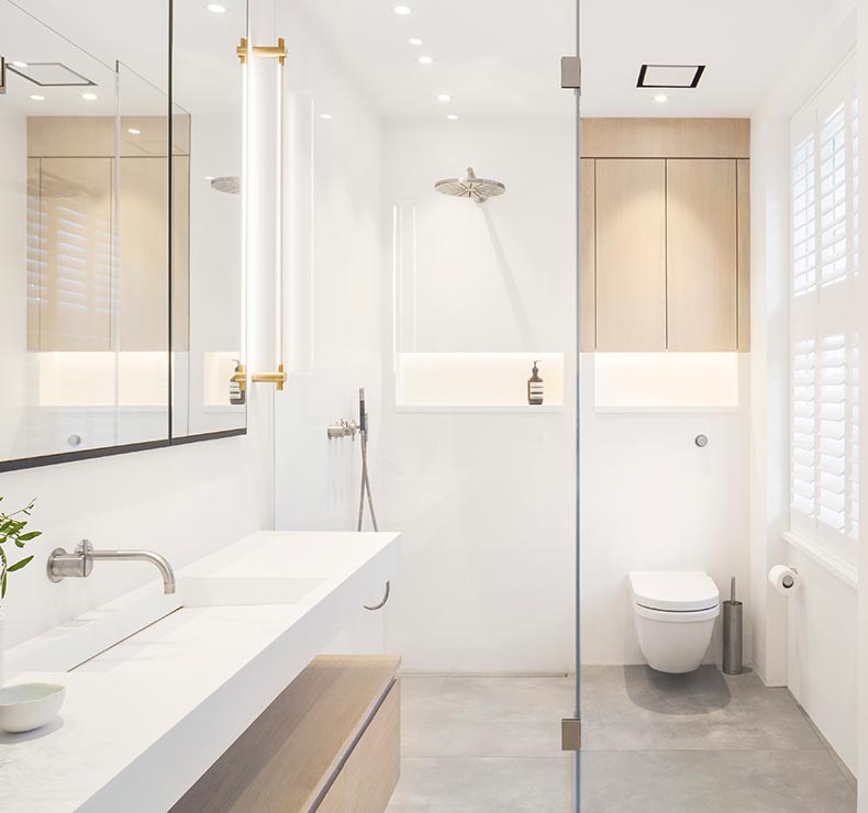 modern white bathroom with sink, toilet, mirror cabinets and shower with fixed shower head