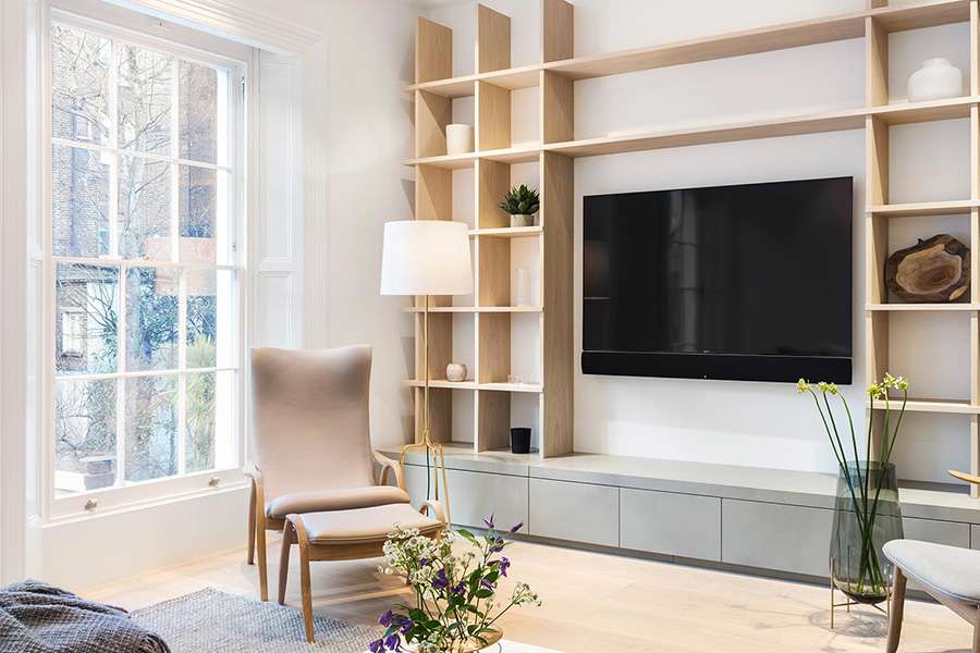 Modern TV room with large wooden display case and grey suspended cabinets.