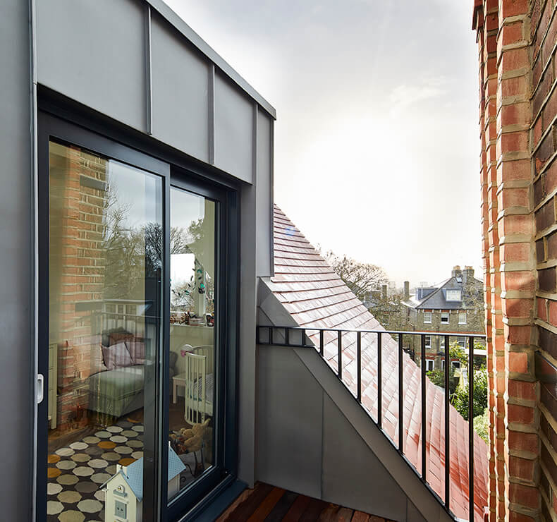top balcony with wooden flooring and black pane glass door