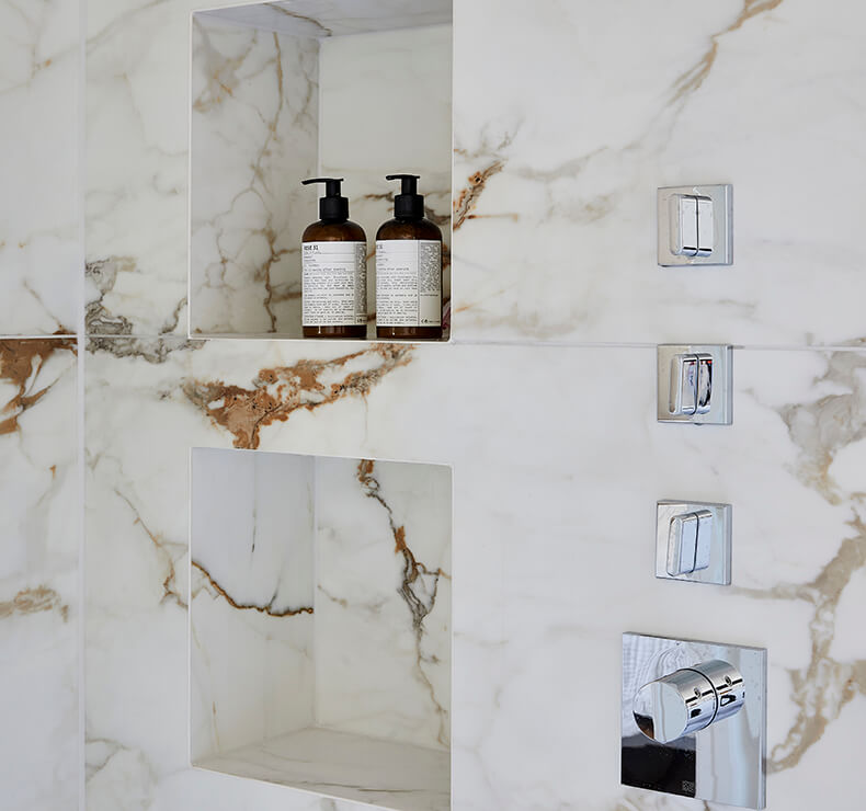 white and brown marble tiled bathroom with cubby