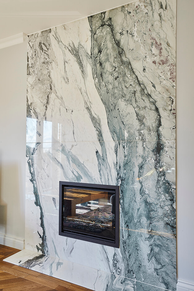 modern lounge room with hole in wall fire place and marble tiled wall