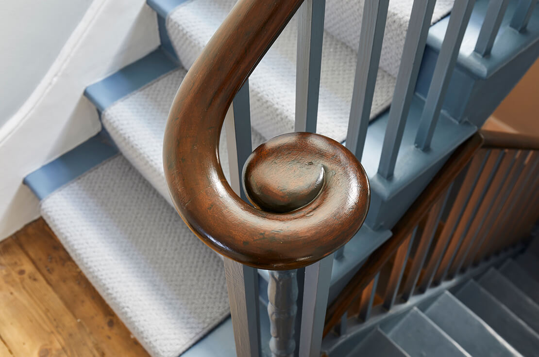 grey staircase with brown handrail
