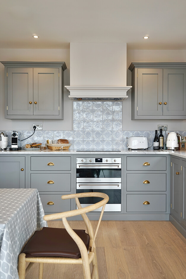 grey kitchen with induction cook top and wooden flooring