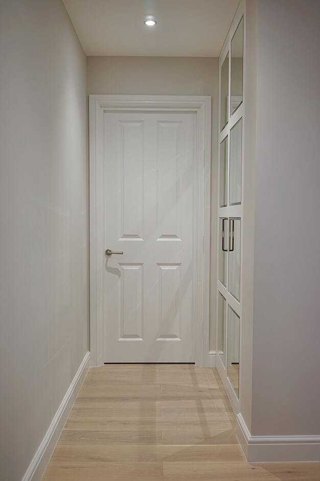 hallway storage space with wooden flooring and white walls