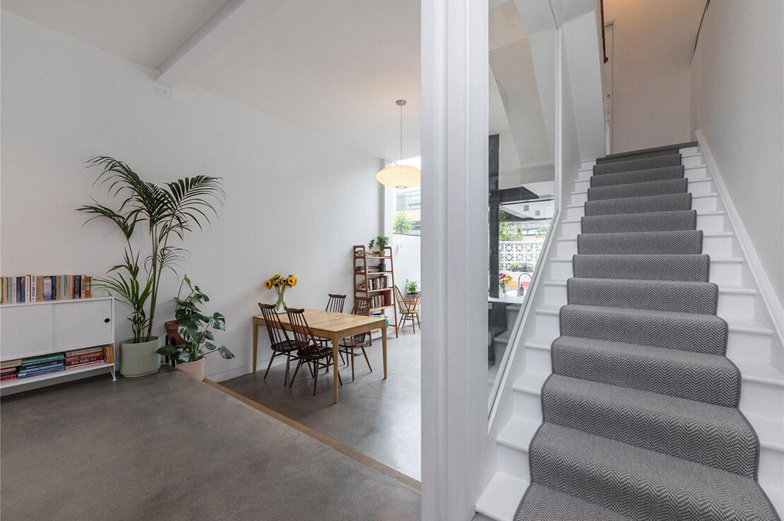 white staircase with grey carpet and view to dining area