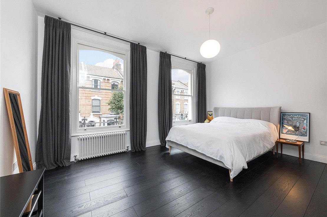 bedroom with dark flooring and white walls