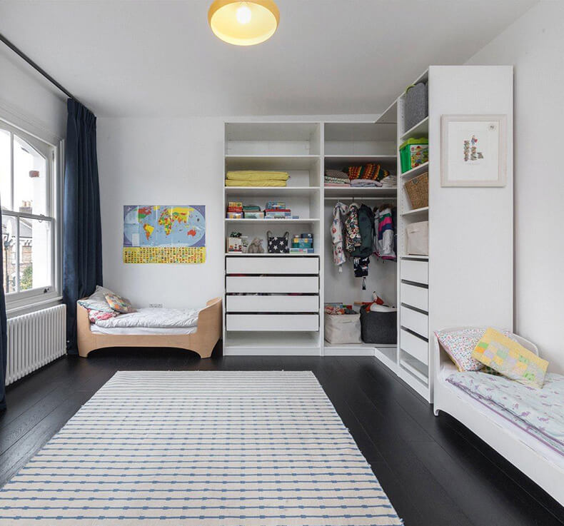 children's room with black wood flooring and open corner wardrobe