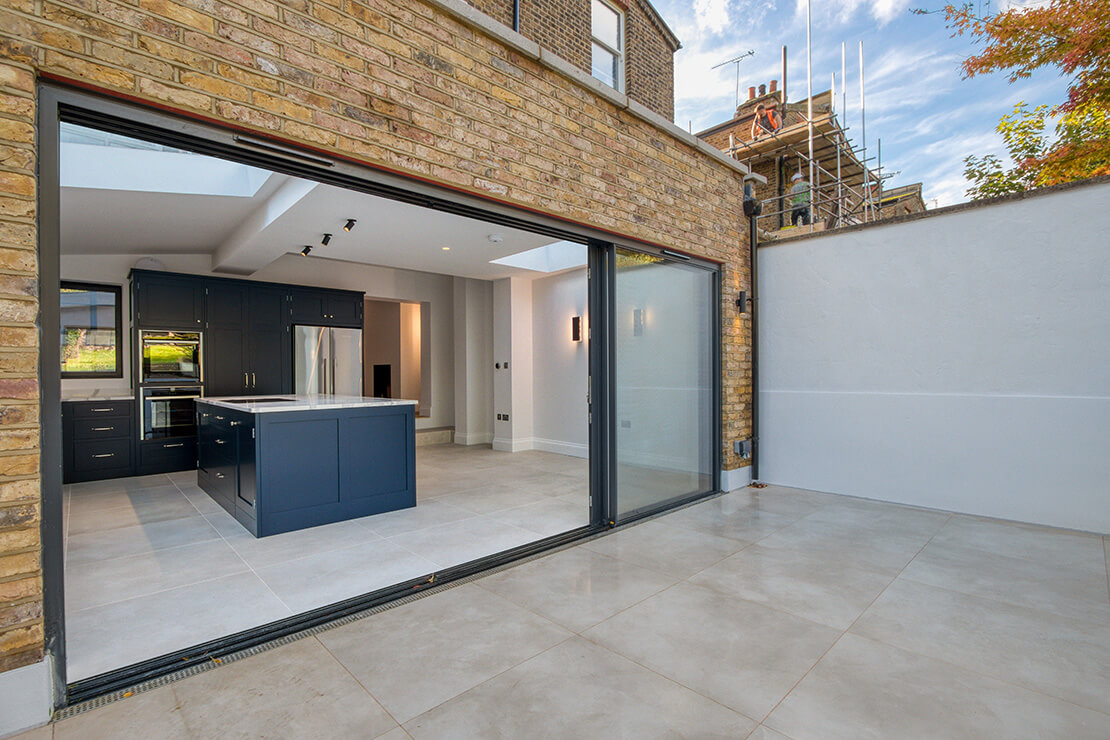 Rear Home brick extension with bifold doors and Light Taupe Flooring.