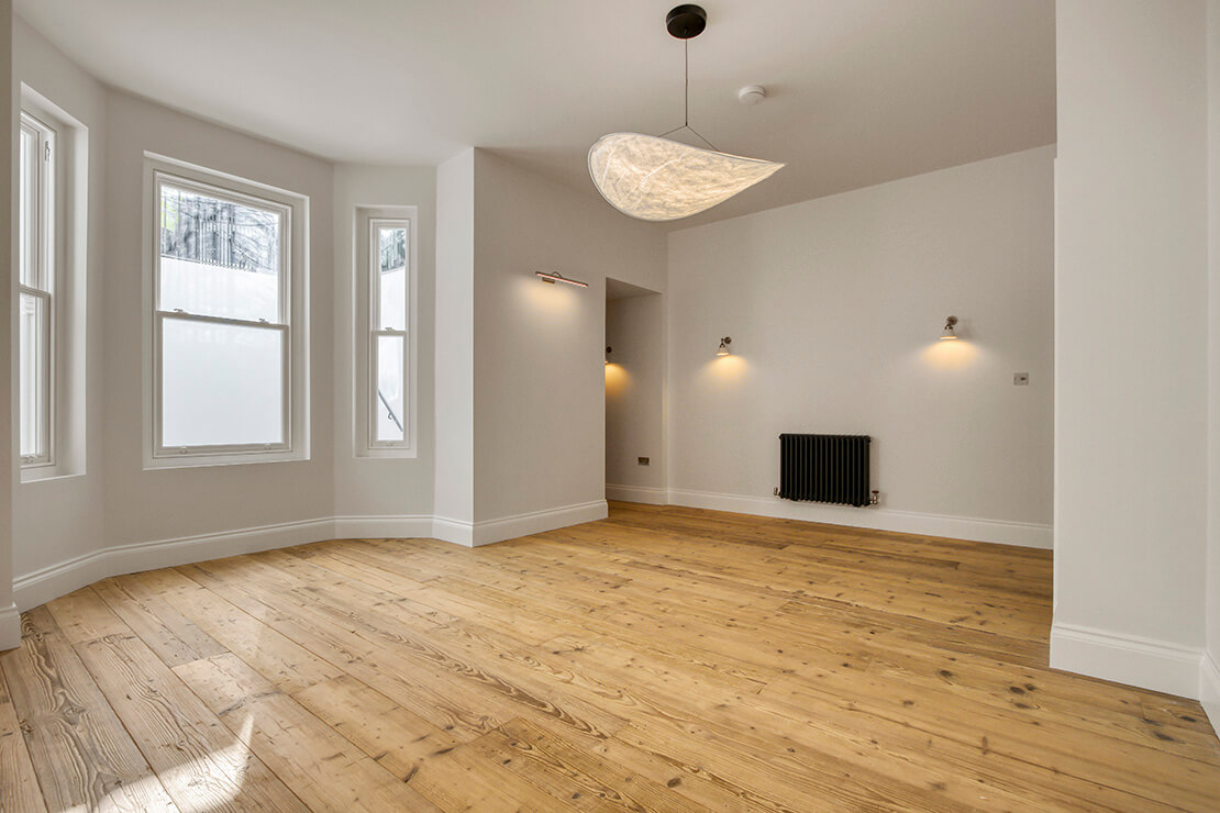 Modern Domestic Room Design with Light Beige and Dark Brown Wood Flooring, featuturing chandelier and blue radiators