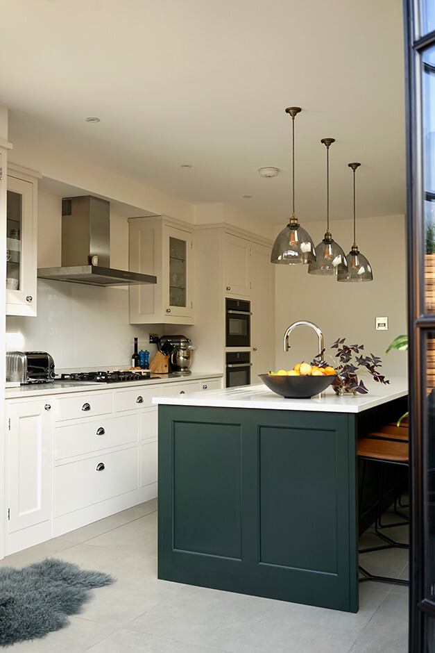 modern white kitchen with white and black island and wall ovens