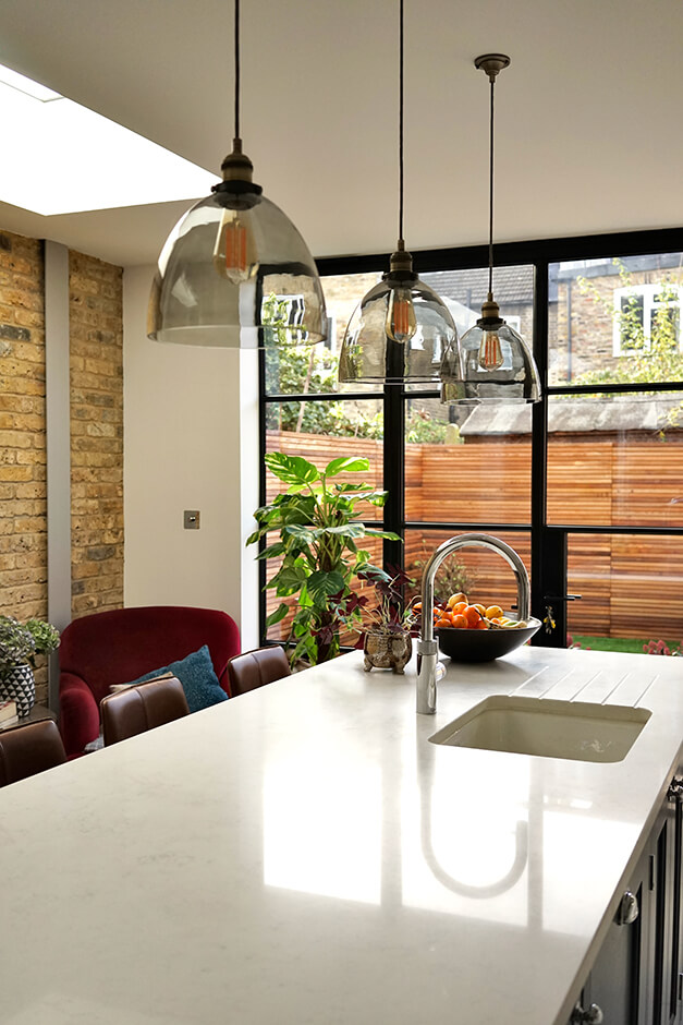 kitchen island with white top, blue cabinets, and modern island sink 