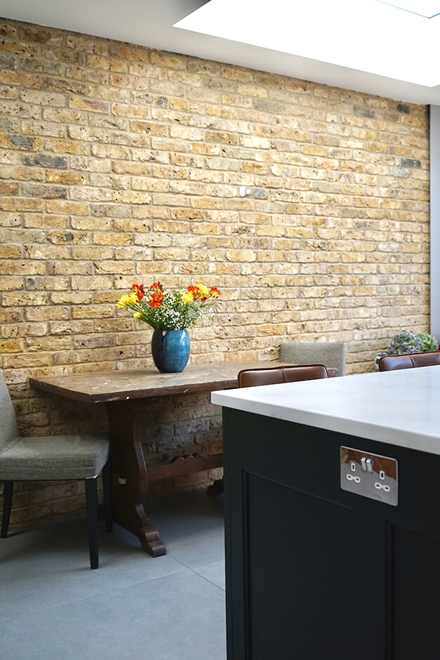 brown brick interior wall in kitchen with small dining set