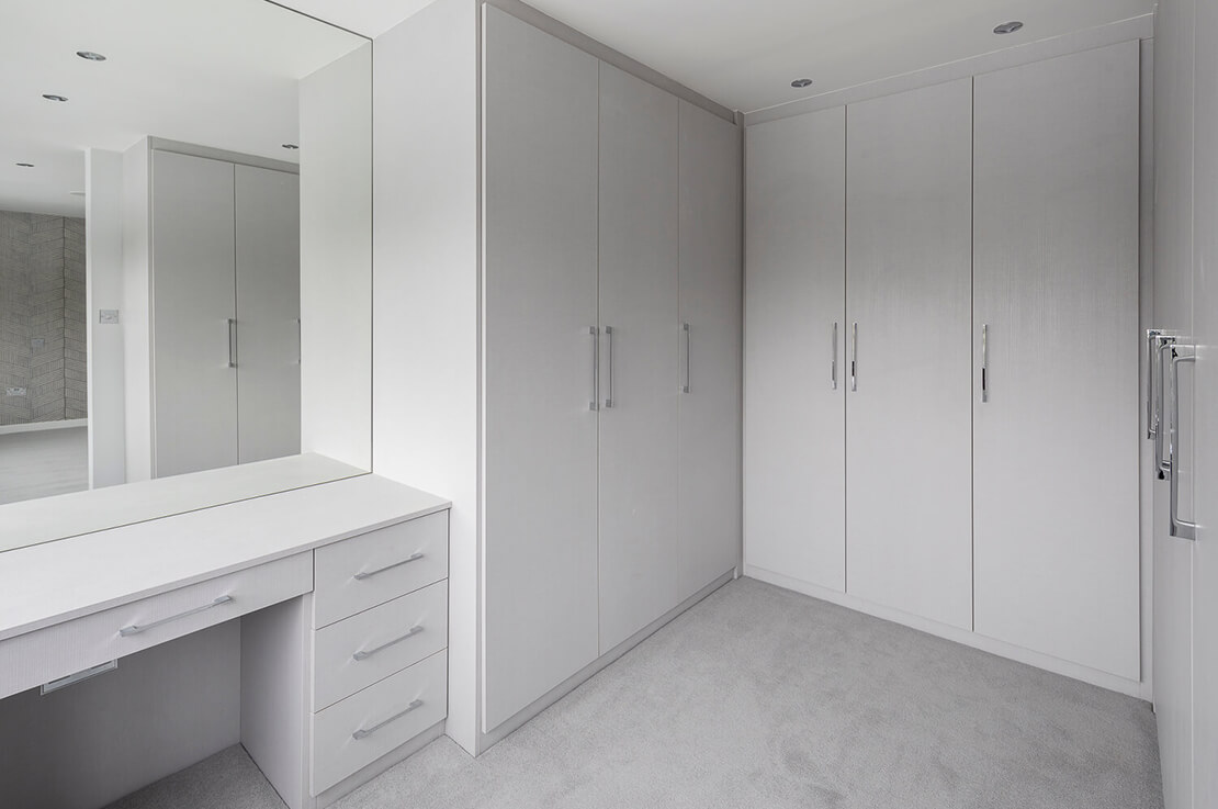 walk-in wardrobe with large cabinets and large mirror