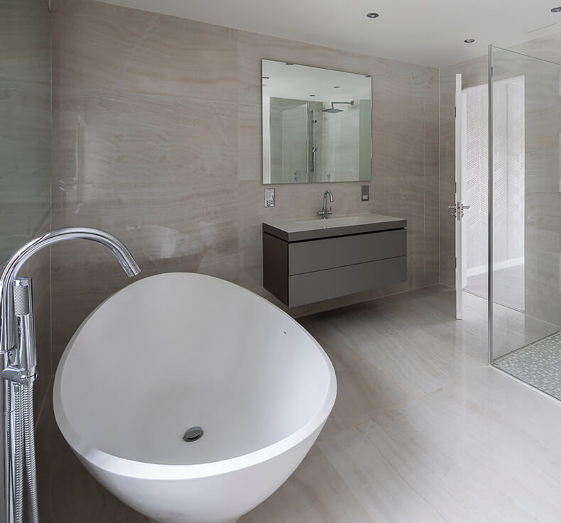 modern bathroom with freestanding tub, sink with cabinet and mirror, and glass door shower
