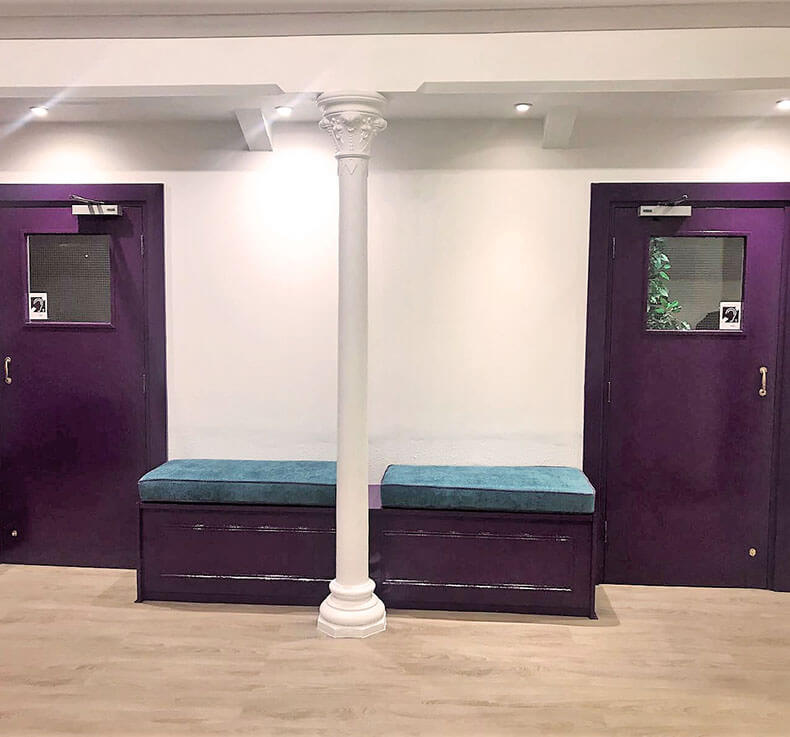 white waiting area with wooden flooring and a white pillar