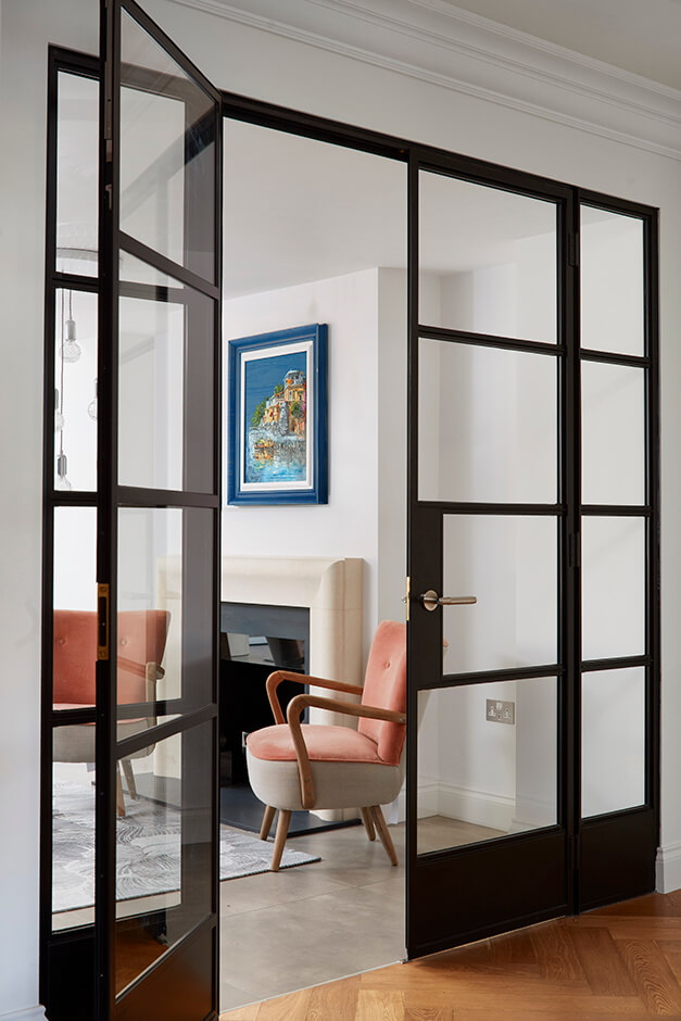 mini sitting room with wooden flooring and black paned glass door