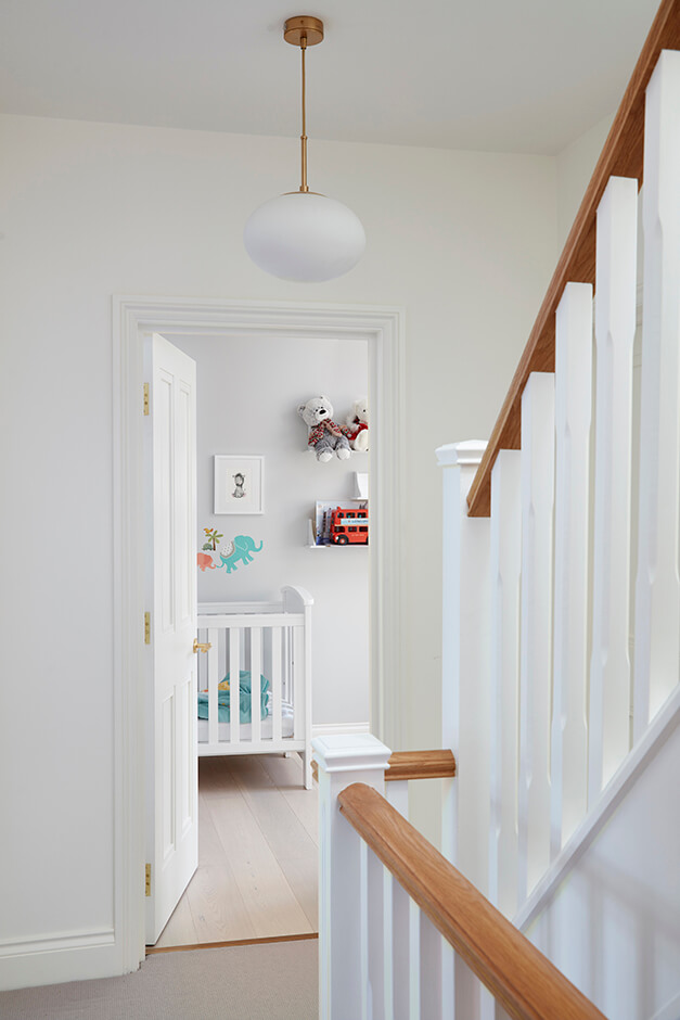 white nursery room with white cot and wall decorations