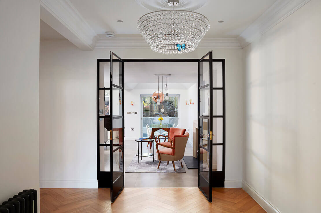 white hallway with wooden floor and black paned glass door