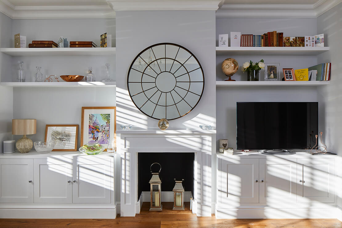 TV room with white display with shelves, mantel and cabinets
