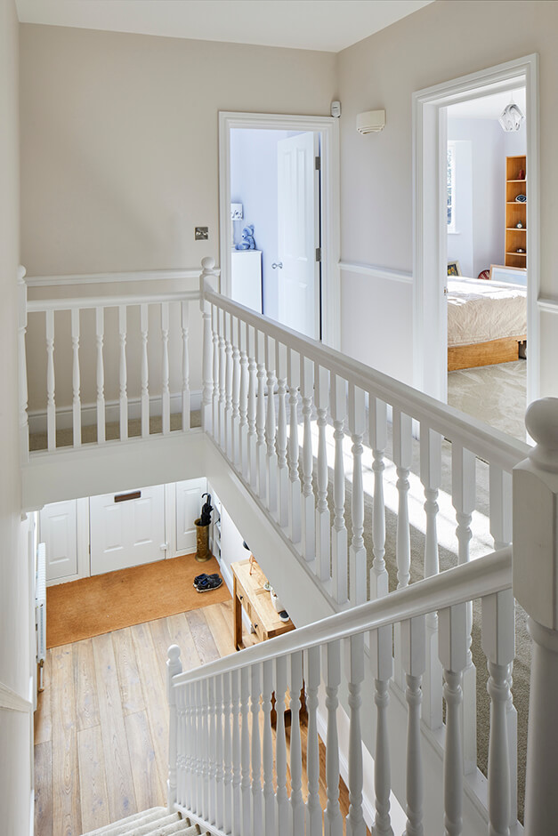 white staicase with white railing and wooden floors