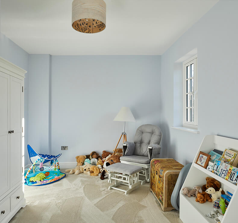 nursery room with recliner arm chair, children's toys and small bookcase 