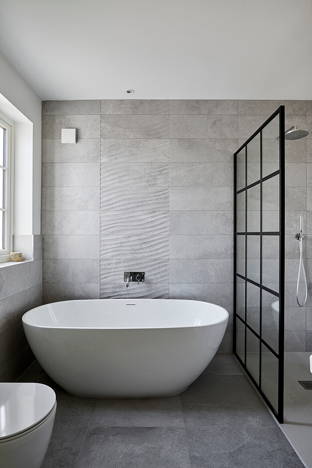 grey tiled bathroom with freestanding bath tub and modern shower