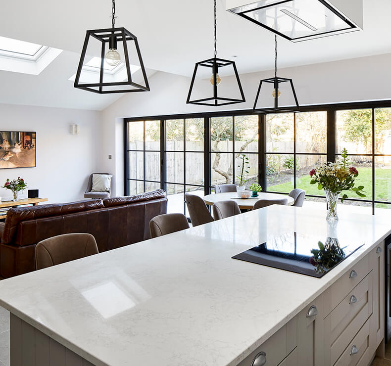 open plan lounge, kitchen with white island and induction cook top and small dining room 