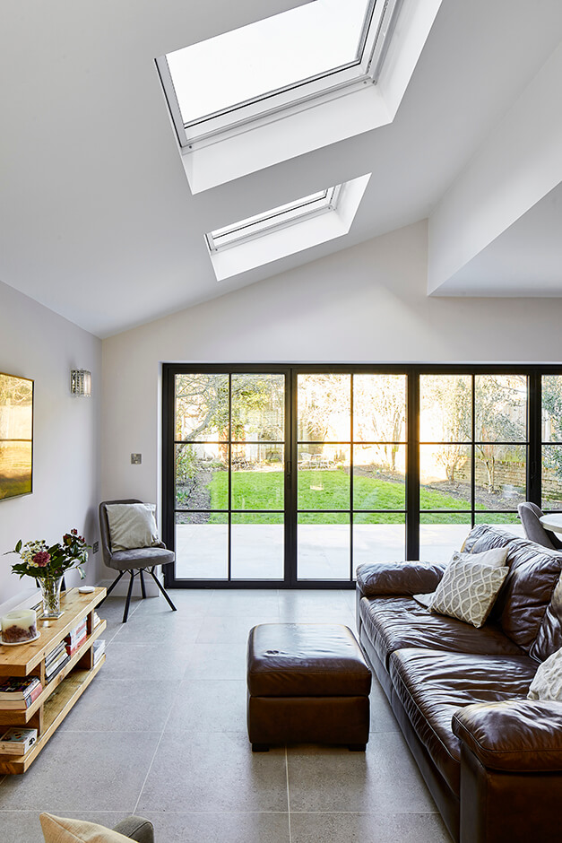 lounge room with skylight and garden view with black paned glass windows