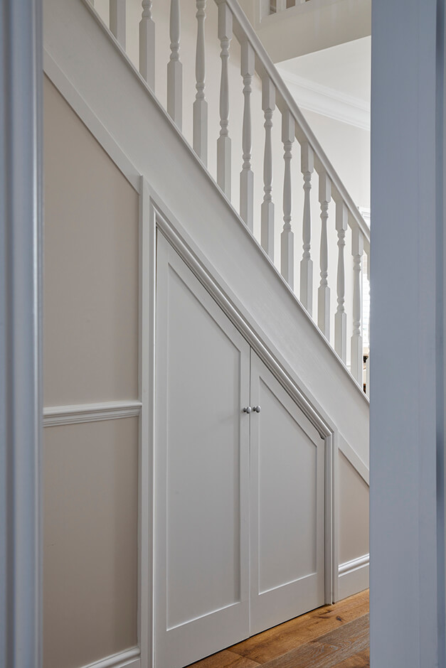 white staircase with white railing and storage space