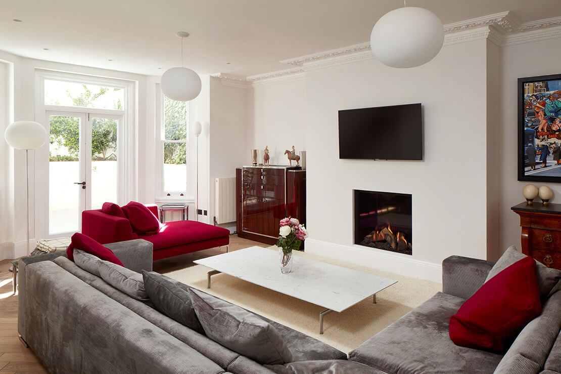lounge room with fireplace, wooden floors, crimson and grey sofas