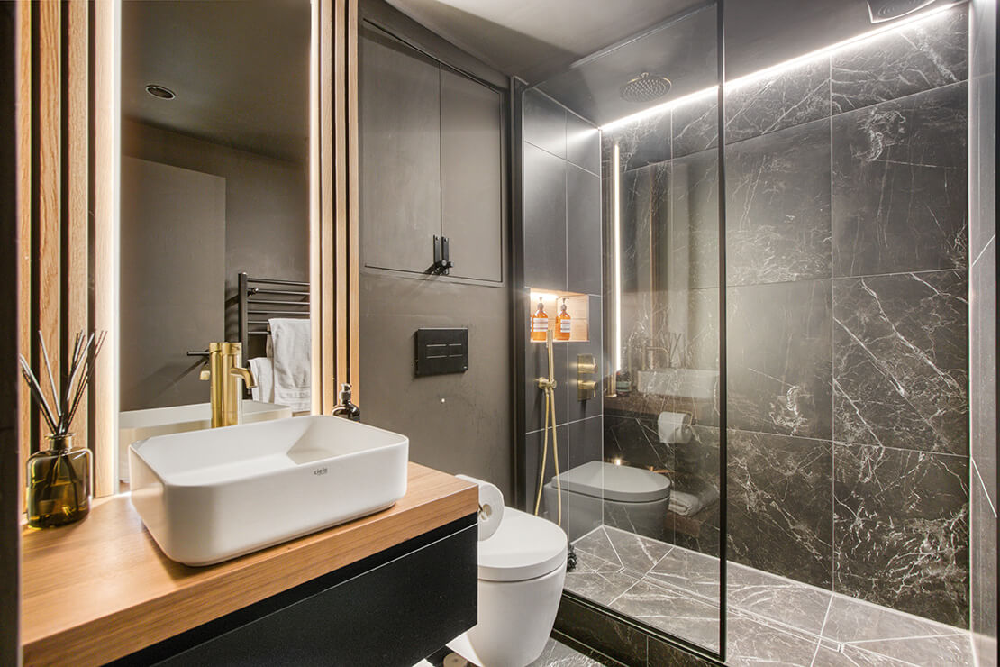small dark bathroom suite with led lighting