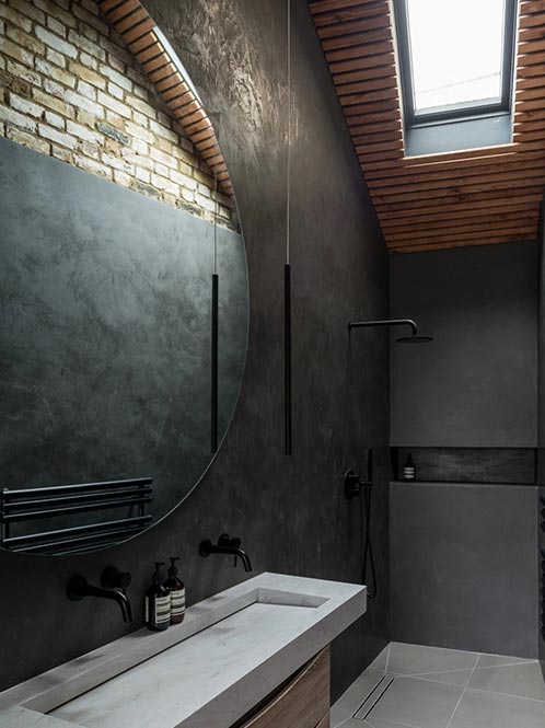 dark grey modern bathroom with skylight, dual sink, fixed shower head and large wall mirror