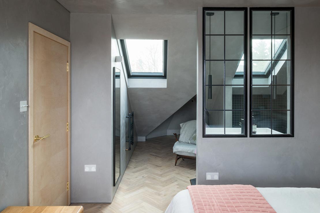 loft bedroom with wooden flooring and lounge area with velux window