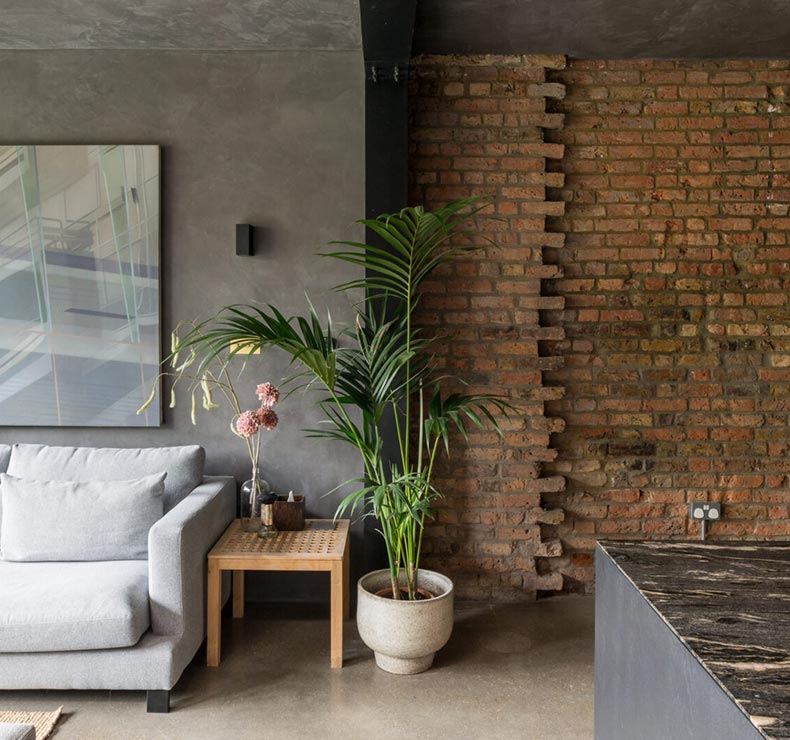 lounge area with marble floors and rough brick interior wall