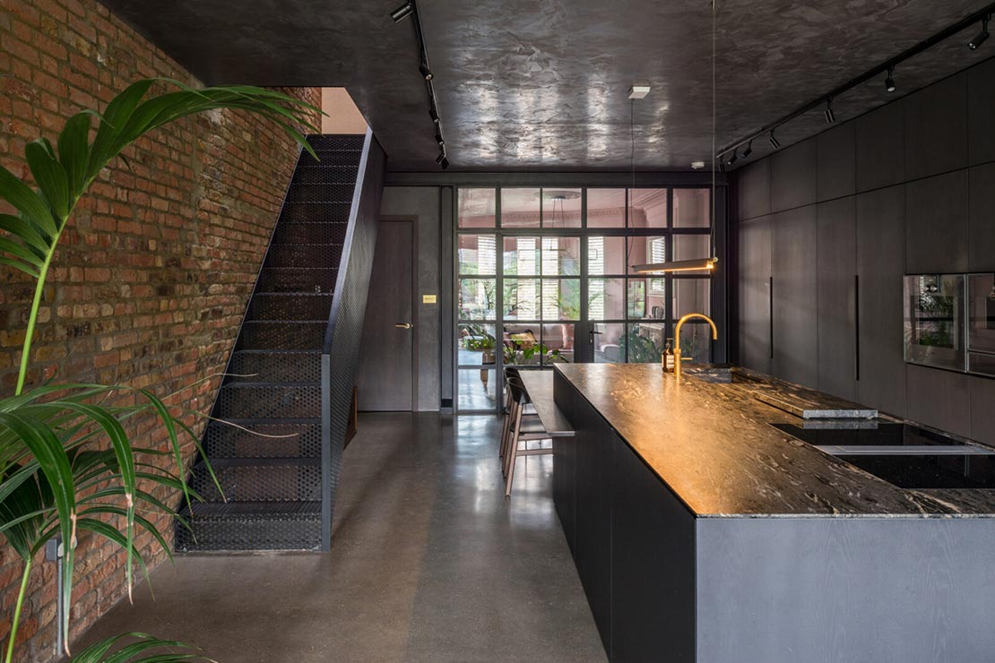 large brown modern kitchen with marble top island with sink