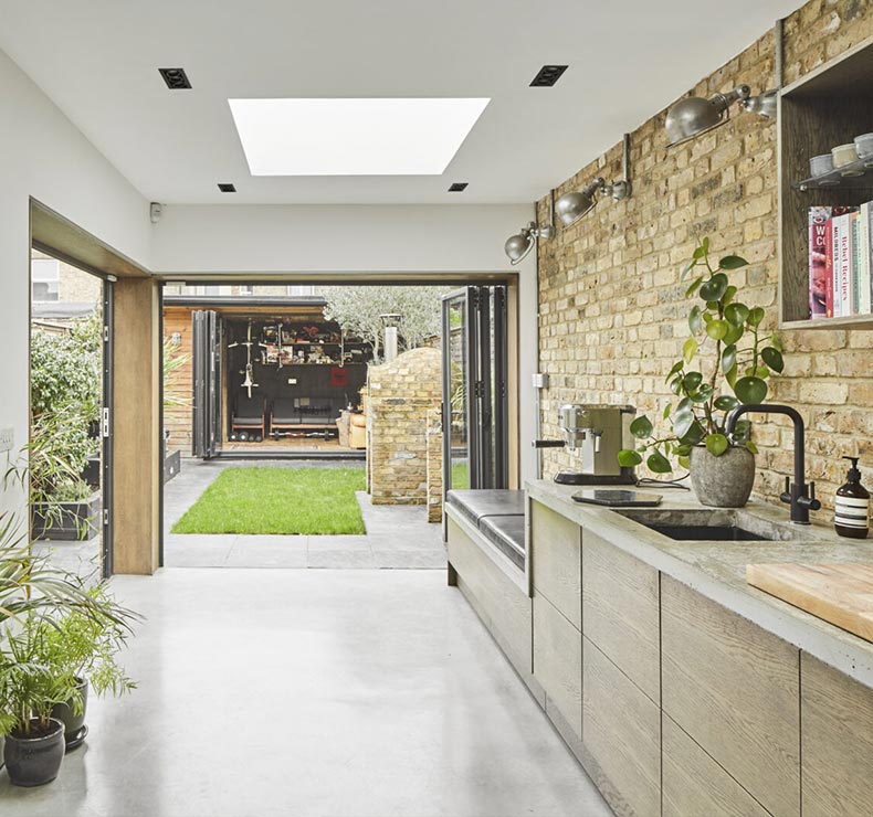 open plan kitchen living room with bifold doors leading to a garden