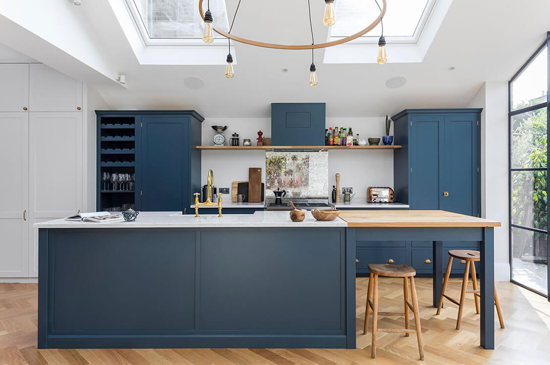 blue kitchen with island and bifold door