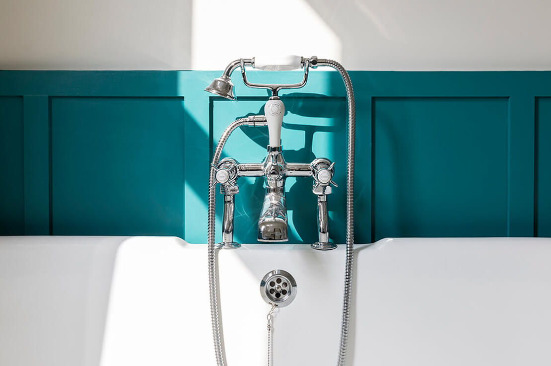 white walled bathroom with tub and silver faucets
